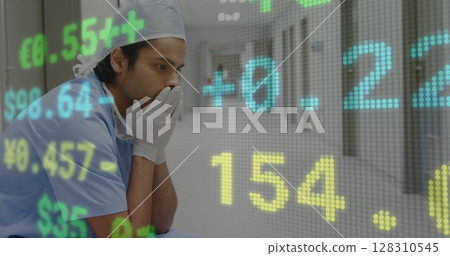 Stock market data processing against stressed male surgeon sitting in the corridor at hospital Stock market data processing against stressed male surgeon sitting in the corridor at hospital 128310545
