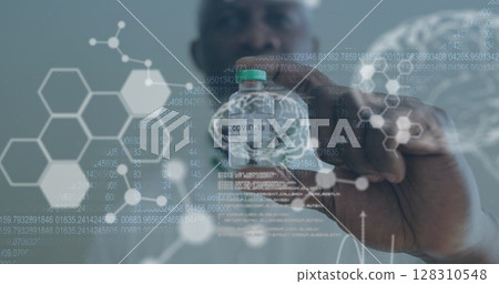 Medical data processing against male doctor wearing face mask holding covid 19 vaccine 128310548