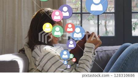 Image of digital people icons over woman reading book and smiling at home 128310686