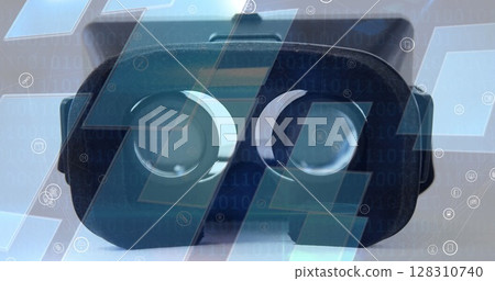 Image of digital icons over screens and vr headset in background 128310740