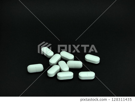 Pile of pills on black background Pile of pills on black background 128311435
