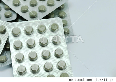 Herbal tablets in foil blister packs on white background 128311448