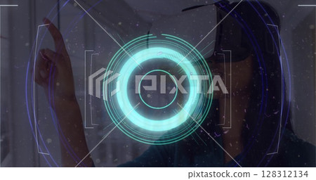 Light trails over neon scope scanner against woman gesturing while wearing vr headset at office 128312134