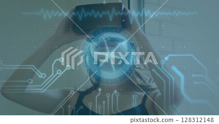 Image of scope scanning and data processing over woman wearing vr headset Image of scope scanning and data processing over woman wearing vr headset 128312148