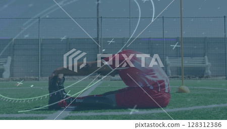 Image of scope scanning over male football player stretching legs on pitch 128312386