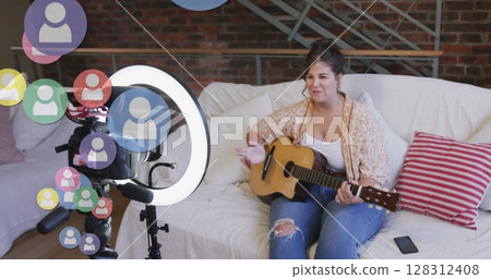 Image of people icons over female vlogger playing guitar recording vlog at home 128312408