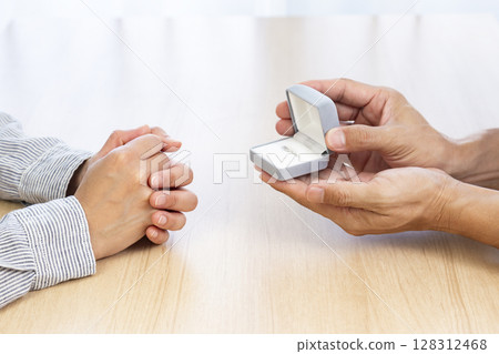 Hands presenting a ring 128312468