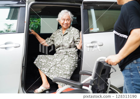 Caregiver help Asian elderly woman disability patient get in her car. 128313190