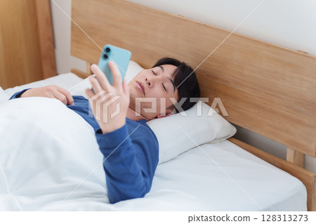 男人早上在床上看智慧型手機 128313273