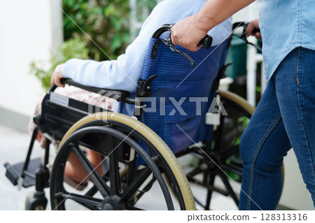 Caregiver help Asian elderly woman disability patient sitting on wheelchair in hospital. Caregiver help Asian elderly woman disability patient sitting on wheelchair in hospital. 128313316