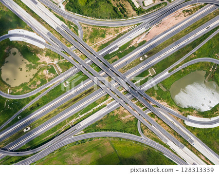 Drone shot a large highway interchange crossing over green farmlands in Thailand 128313339