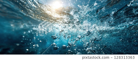 Bubbles rise towards the surface, with sunlight filtering through clear blue water. 128313363