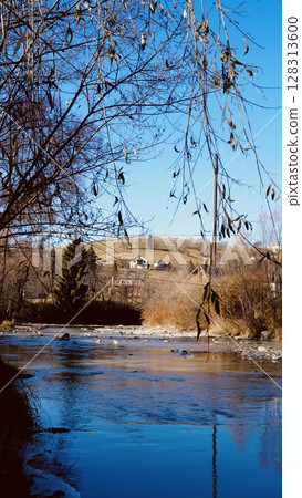 A Serene River Landscape Displaying the Beauty Under a Clear Blue Sky with Tranquility 128313600