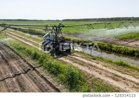 Autonomous machine is moving watering pivot along irrigation canal Autonomous machine is moving watering pivot along irrigation canal 128314113