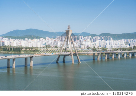 Beautiful view of modern tower and Jamsil Railway Bridge over the Han River (Hangang) at downtown of Seoul in South Korea. Scenic skyscraper is visible on blue sky background. Wonderful cityscape. 128314276