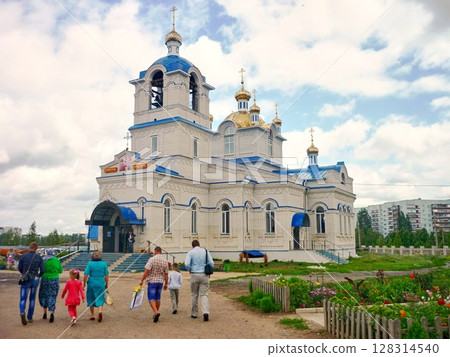In the summer, a group of adults with children visits an Orthodox church. 128314540