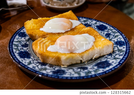 Roti bakar telur goyang or toast bread with half boiled eggs, popular breakfast delicacy in Ipoh, Malaysia Roti bakar telur goyang or toast bread with half boiled eggs, popular breakfast delicacy in Ipoh, Malaysia 128315662