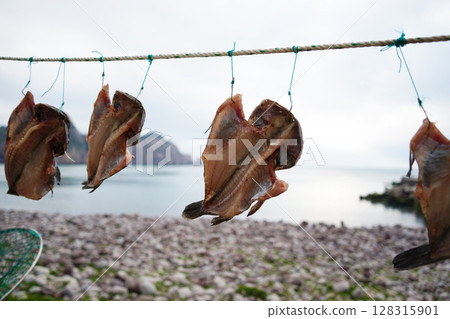 Dried Fish Hanging on Rope by the Sea in Korean Coastal Village 128315901
