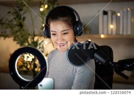 Podcasting. Engaging woman recording her podcast with microphone and headphones. 128316074