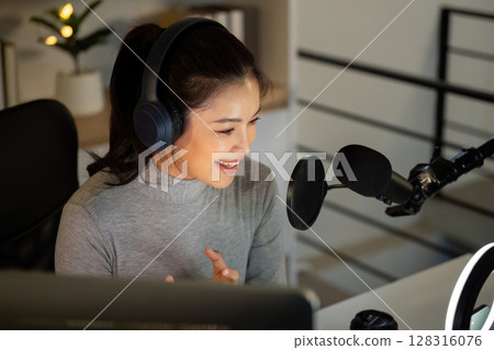 Podcasting. Happy woman hosting her podcast session with professional equipment. 128316076
