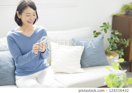 A middle-aged woman operating a smartphone A middle-aged woman operating a smartphone 128316432
