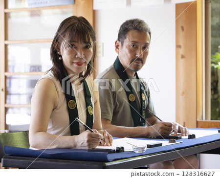 A couple experiencing copying sutras at a temple 128316627