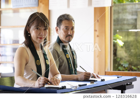 A couple experiencing copying sutras at a temple 128316628