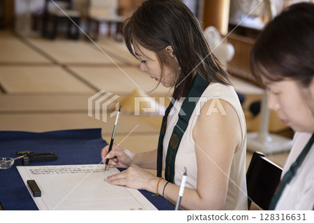 A woman experiencing copying sutras at a temple 128316631
