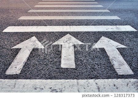 Three arrows on asphalt point forward a powerful symbol of purpose, progress, and moving ahead with clarity and determination. Three arrows on asphalt point forward a powerful symbol of purpose, progress, and moving ahead with clarity and determination. 128317373
