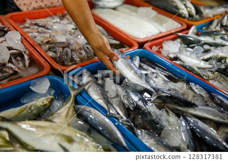 Assorted fresh fish on trays at seafood market display 128317381