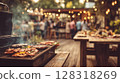Grilling delicious meats and vegetables on barbecue grill outdoors, with smoke rising in the air, surrounded by vibrant atmosphere 128318269
