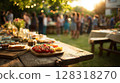 Outdoor gathering featuring a beautifully arranged table with assorted dishes, fresh vegetables, and drinks 128318270