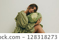 Fashion model poses with fresh produce in a modern studio setting during a creative photoshoot 128318273