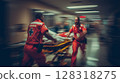 Emergency medical technicians in red uniforms rush through hospital corridor with stretcher, showcasing urgency and teamwork in critical healthcare environment during life-saving operation 128318275