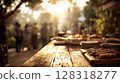 Outdoor gathering with friends enjoying a barbecue party, featuring a wooden table laden with grilled food, 128318277