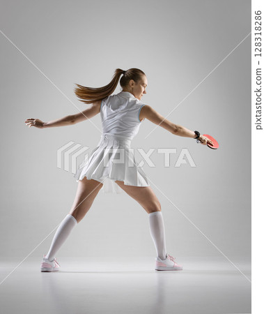 Female athlete playing table tennis with intensity and style 128318286