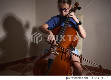 Young Musician Practicing the Cello in a Peaceful Indoor Setting 128319106