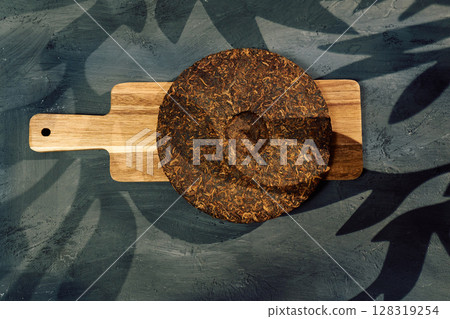 Discovering the rich texture and aroma of puer tea on a wooden board in a serene setting Discovering the rich texture and aroma of puer tea on a wooden board in a serene setting 128319254