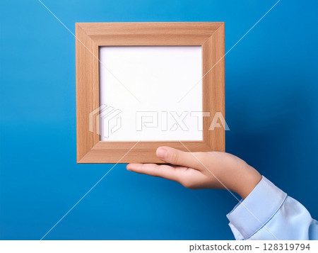 Child's hands holding a wooden frame 128319794