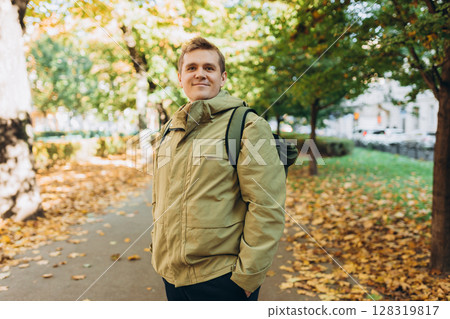 Calm happy 30s Man Relaxing in Autumn Park Outdoors. Traveler. Falling time. Smiling man in casual clothing standing outdoor Calm happy 30s Man Relaxing in Autumn Park Outdoors. Traveler. Falling time. Smiling man in casual clothing standing outdoor 128319817