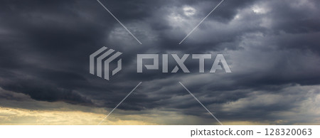 The dark sky, heavy with swirling clouds, signals an impending windstorm, highlighting the dramatic changes in weather and the immense power of nature. 128320063