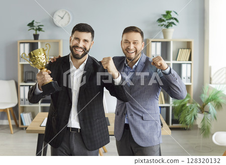 Business people holding the trophy award for success in business standing in office 128320132