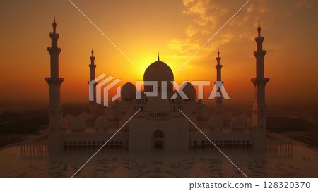 beautiful landscape photograph of a mosque at sunset. The sky is a gradient of orange hues 128320370