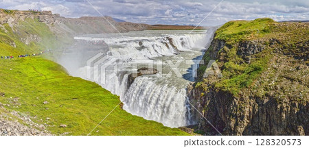 Panoramic view of Gullfoss waterfall Iceland with cliffs and green landscape 128320573
