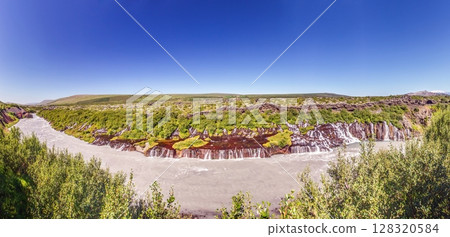 Panoramic view of Hraunfossar waterfall Iceland with lava rocks and green landscape 128320584