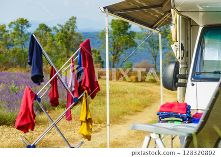 Clothes hanging to dry outdoors by camping car. Caravan vacation. 128320802