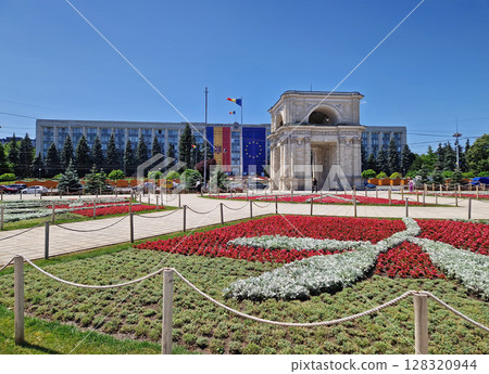 CHISINAU, MOLDOVA - JUNE 20, 2025 Triumphal Arch as popular historical landmark of the capital with the Moldovan Government House in the background 128320944
