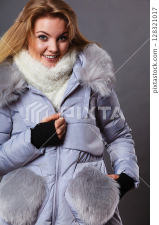 Woman wearing winter warm furry jacket 128321017