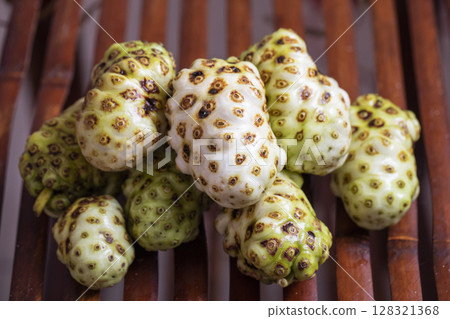Exotic Noni Fruits Beautifully Arranged on a Rustic Wooden Surface for an Appealing Look Exotic Noni Fruits Beautifully Arranged on a Rustic Wooden Surface for an Appealing Look 128321368