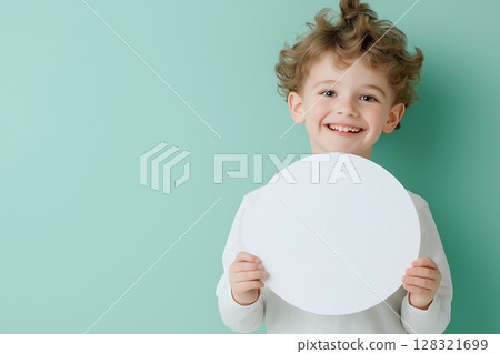 Happy child with curly hair holding a circle on green background in cute portrait 128321699